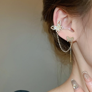 Detailed close-up of a zircon butterfly ear cuff with chain connection in gold plating