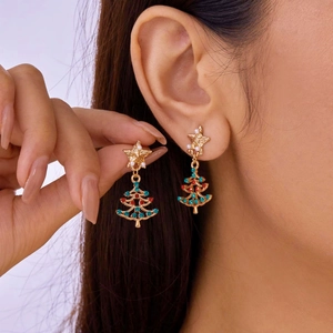 Close-up of gold star and Christmas tree earrings with colorful gems and pearls