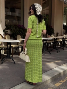 Detail of green hollow crochet knit fabric on a slim short-sleeve top and maxi skirt set