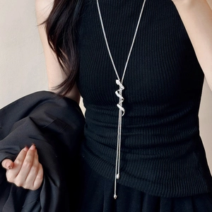 Silver snake pendant necklace with rhinestones and long tassel on black knit top