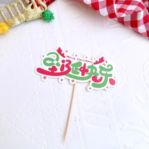 Macro shot of Merry Christmas cake topper with wooden stick on festive background