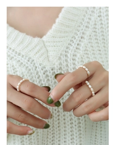 Détail de trois bagues ajustables en perles de culture avec finitions en or 18 carats