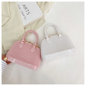 Close-up of pink and white jelly shell bags with woven texture and gold hardware details