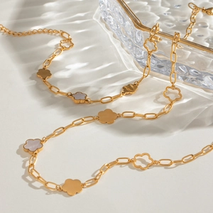 Gold stainless steel 18K flower bracelet with white clover charms on a ripple surface