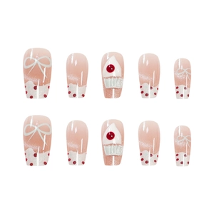 Pink cat-eye press-on nails with white 3D bows and cute red polka dot cake patterns