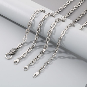 Detail of square link silver chains featuring a unique casted snake head clasp design