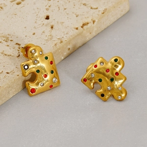 Detailed macro view of gold puzzle earrings featuring colorful inlaid zirconia crystals