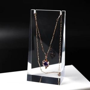 Detail of rose gold necklace with purple gemstone pendant on acrylic display stand