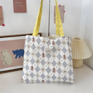 Detail of cute teddy bear jacquard fabric and yellow straps on large canvas tote bag