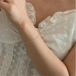 Close-up of minimalist 925 sterling silver beaded bracelet on wrist with lace details