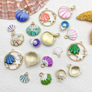 Detailed close-up of colorful enamel seashell charms with pearls for DIY jewelry making