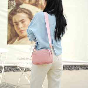 Detail of pink PU crossbody bag with lychee texture and adjustable wide shoulder strap