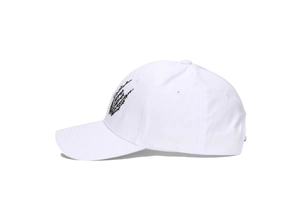 Detail of white cotton baseball cap with black skull palm embroidery in street style
