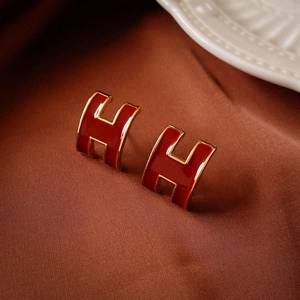 Close-up of vintage wine red enamel H-shaped stud earrings with elegant gold-tone plating