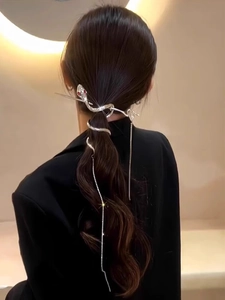 Silver snake hair pin with red eyes and long tassel chain on professional model hair