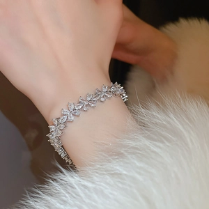 Gros plan détaillé d'un bracelet fleuri argenté serti de zircons brillants sur fourrure
