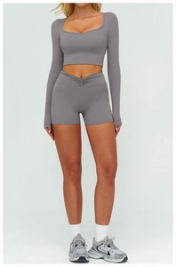 Détail d'un haut de yoga gris à manches longues et d'un short à taille haute en V croisé