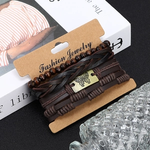Détail du bracelet multi-rangs en cuir avec perles de bois et breloque papillon bronze