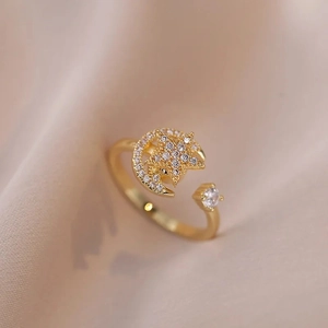 Bague ajustable dorée étoile et lune avec zircons étincelants sur fond en soie beige