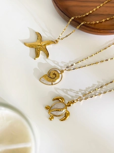 Detail of 18K gold plated ocean necklaces with starfish, sea turtle, and shell pendants