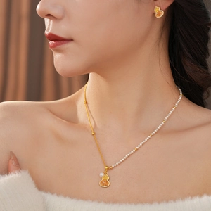 Gros plan détaillé sur des boucles d'oreilles et collier en perles plaqués or 18 carats