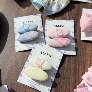 Detail of fabric hair clips with cute cat charms and puppy embroidery in pastel colors