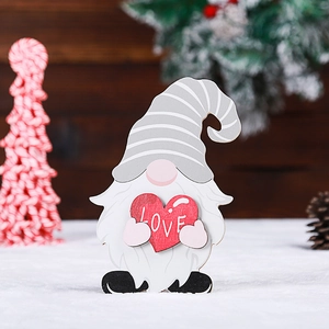 Close-up of a wooden gnome ornament holding a red heart with white LOVE lettering