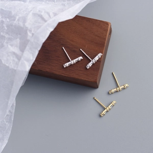 Detail of T-bar stud earrings in silver and gold plating with sparkling zircon stones