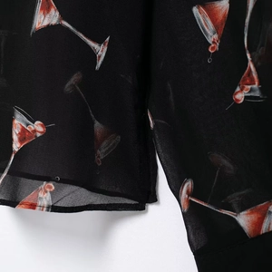 Chemisier en mousseline avec imprimé martini rouge sur tissu noir léger et aéré