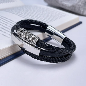 Macro detail of men's multi-layer braided leather bracelet with silver magnetic buckle
