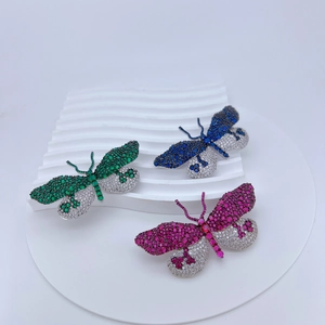 Gros plan de trois broches papillon étincelantes avec incrustations de zircon et métal