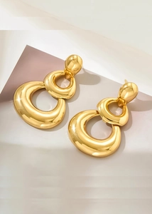 Detail of chunky triple-layered gold teardrop earrings with a polished metallic finish