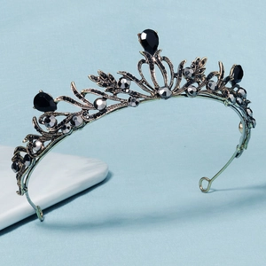 Baroque style bridal crown with black rhinestones and pearls on marble surface