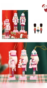 Detailed view of pink and purple 13cm wooden nutcracker soldiers with golden hanging ropes