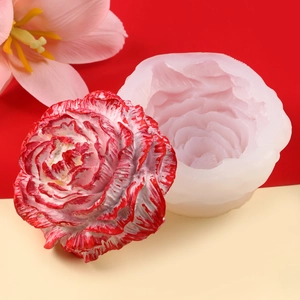 Macro detail of white silicone rose mold beside a realistic red floral candle creation