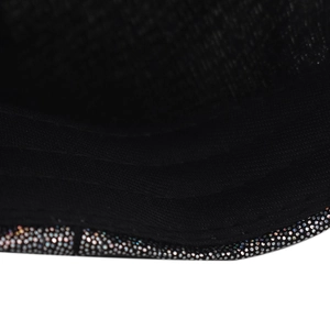 Macro close-up detail of shiny gradient rhinestones on the brim of a black baseball cap