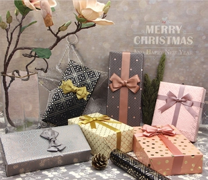 Detail of luxury geometric gift boxes with metallic gold foil patterns and satin ribbons