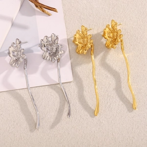 Detailed view of vintage flower drop earrings in polished gold and silver steel finishes
