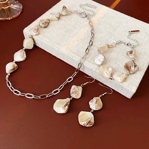 Vue à plat d'une parure de bijoux en coquillage irrégulier avec collier et bracelet
