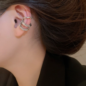 Three-piece silver ear cuff set with shiny zircon stones shown on a model's ear