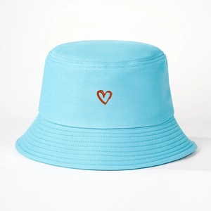 Close-up detail of light blue cotton bucket hat with a small red embroidered heart icon