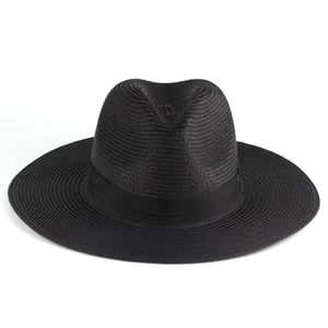 Detailed view of the woven texture and black ribbon on a classic wide brim straw hat
