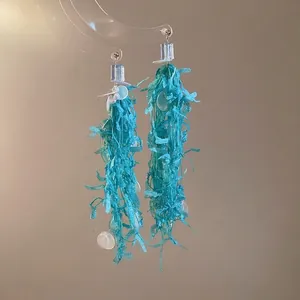 Elegant light blue tassel earrings with white bead accents and silver needle studs