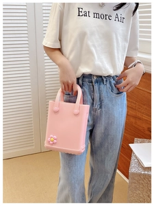 Rosa Mini-Strandtasche aus EVA mit Blumendekor, präsentiert von einem Model