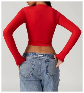 Close-up back view of tight red long sleeve yoga top with cropped waist design