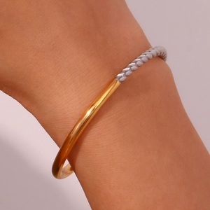 Close-up of a two-tone twisted rope bracelet in gold and silver stainless steel