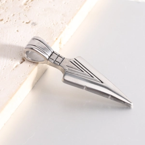 Detail shot of silver arrow pendant in 304 stainless steel on natural stone background
