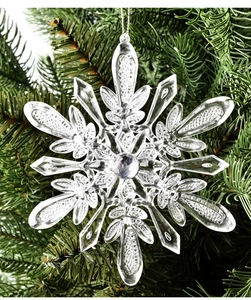 Détail de flocons de neige en acrylique transparent sur une branche de sapin de Noël