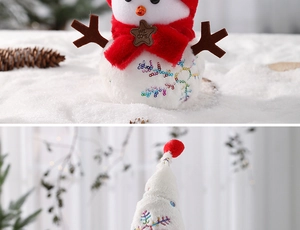 Dettaglio di un pupazzo di neve in peluche con paillettes e targa Welcome natalizia