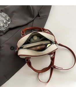 Macro view of interior storage in bicolor Boston bag with zipper and handles